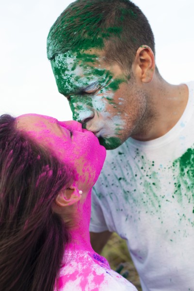 Caucasian couple splattered with paint powder kissing