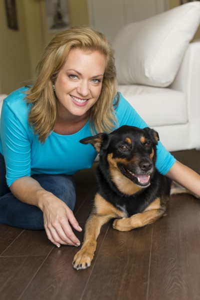 Caucasian woman playing with dog in bedroom