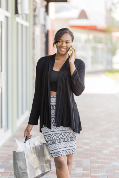 Mixed race woman shopping and talking on cell phone