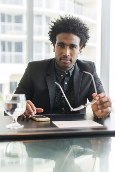 Hispanic businessman using cell phone at conference table