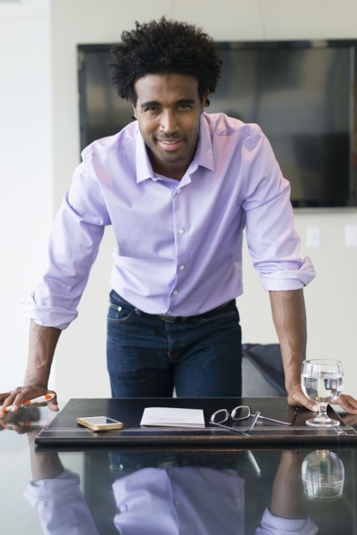 Hispanic businessman leaning over conference table