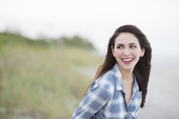 Hispanic woman smiling on beach