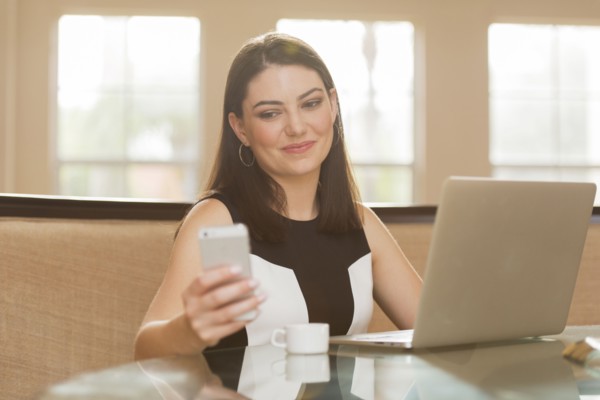 Hispanic businesswoman using cell phone in office