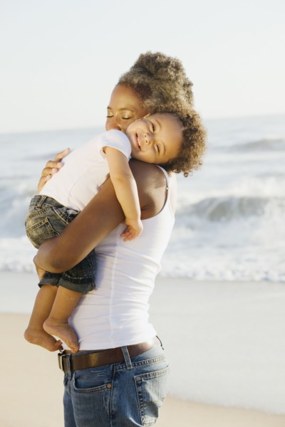 African mother holding son on beach