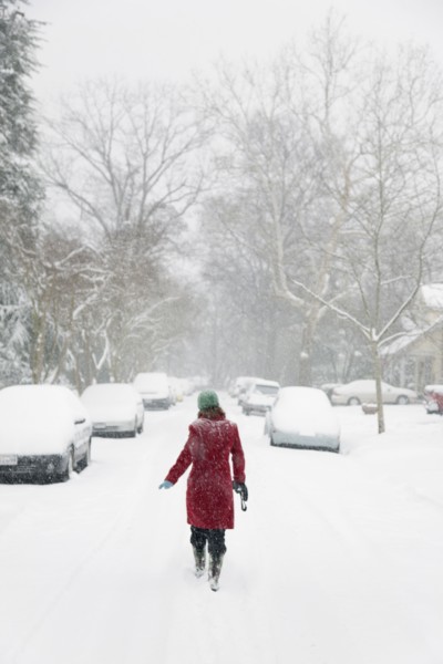 Caucasian woman walking in snow storm