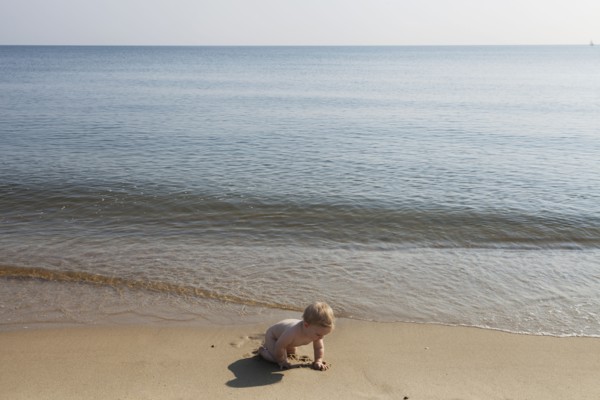 Caucasian baby playing on beach
