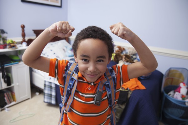 Mixed race boy wearing backpack in bedroom