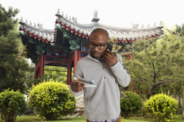 Black man reading map on city street