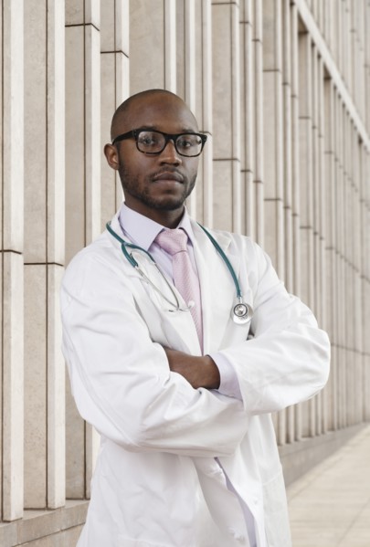 Black doctor standing on city street