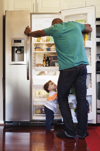 Father and baby looking through fridge