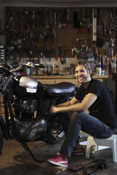 Caucasian mechanic working on motorcycle