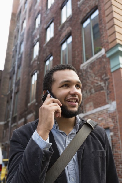 Mixed race businessman talking on cell phone in city