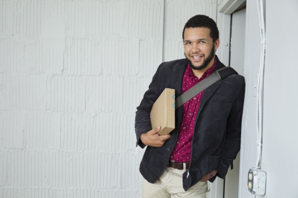 Mixed race businessman holding box in doorway