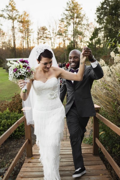 Newlywed couple walking on wooden footbridge