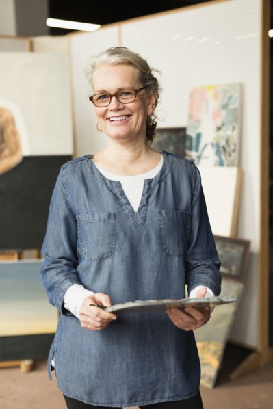 Caucasian artist smiling in studio