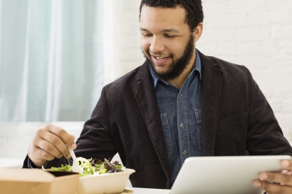 Mixed race businessman eating salad
