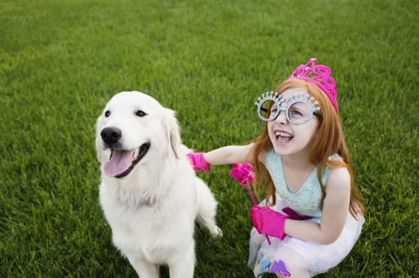 Caucasian girl playing dress up in park