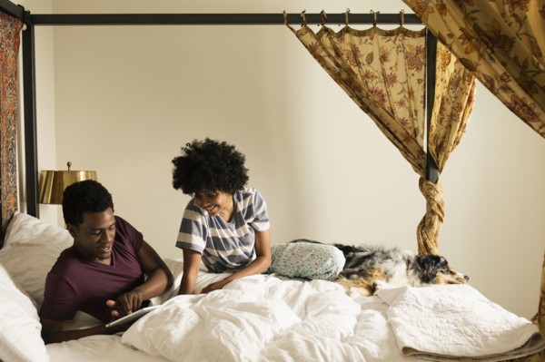 Couple and dog relaxing on bed