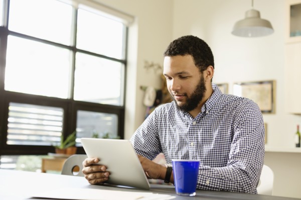 Mixed race businessman using tablet computer at desk