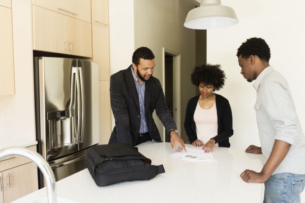 Couple talking to broker in new house