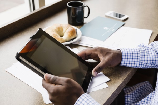 Black businessman using digital tablet in cafe