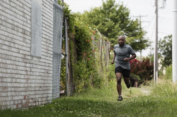 Black man running in urban grass
