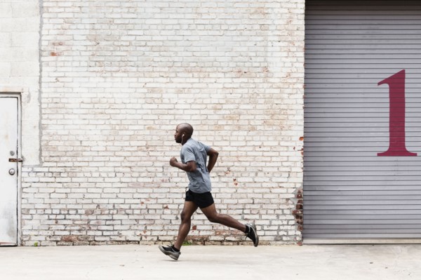 Black man running on city sidewalk
