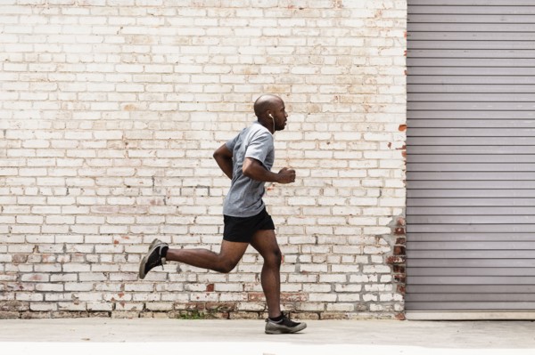 Black man running on city sidewalk