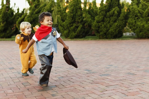 Boys playing in costumes on sidewalk
