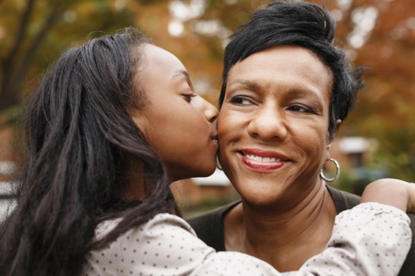 Close up of African American girl kissing mother