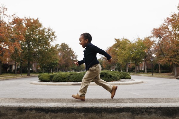 African American boy playing on suburban street