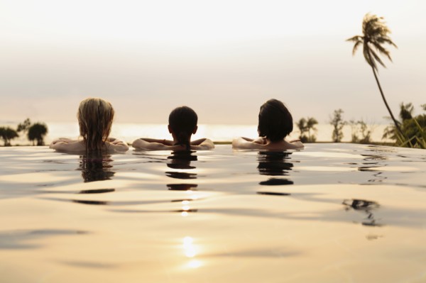 Women admiring scenic view in infinity pool