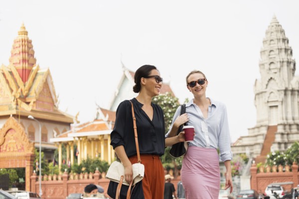 Businesswomen walking by ornate temple