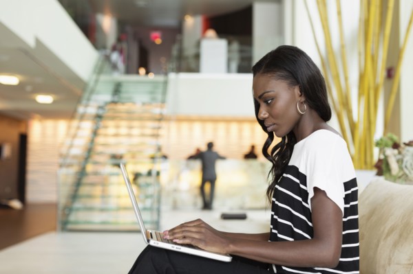 Businesswoman using laptop in hotel lobby