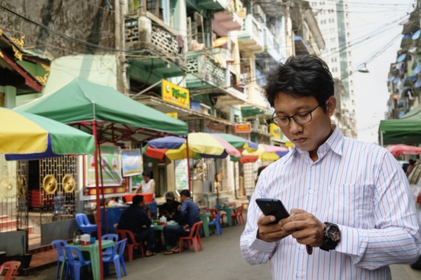 Asian businessman using cell phone in city