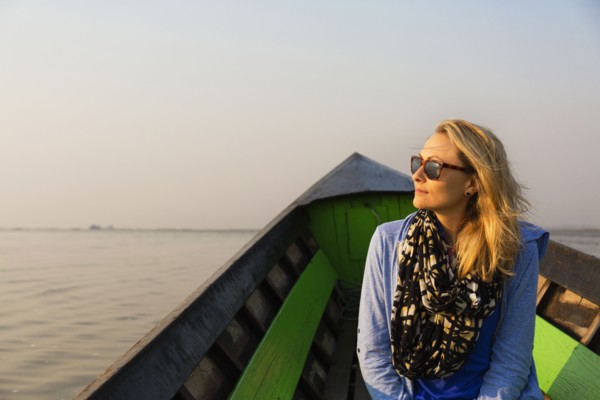 Caucasian woman riding in canoe on rural lake