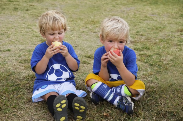 Caucasian soccer players eating apples