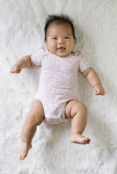 Mixed race baby girl laying on floor
