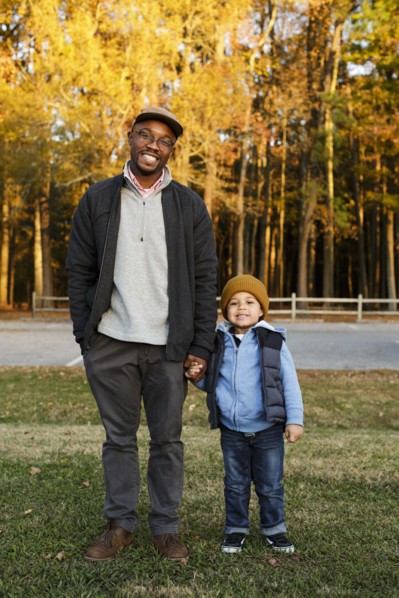 Father and son holding hands in park