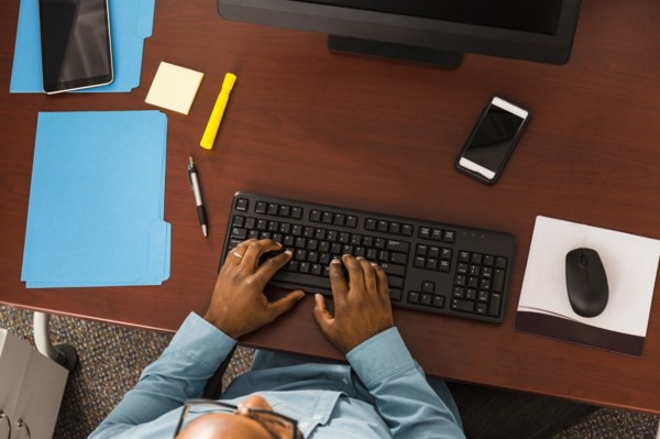African American man typing on computer keyboard in office