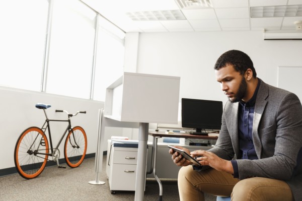 Mixed Race man using digital tablet in office
