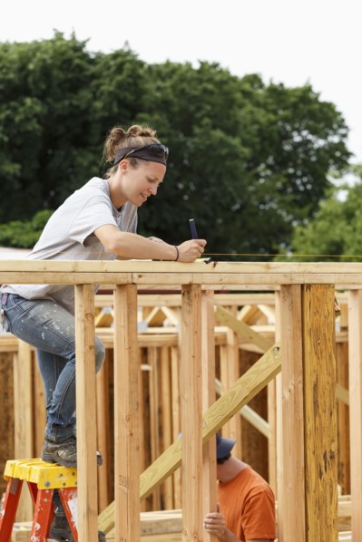 Caucasian woman measuring at construction site