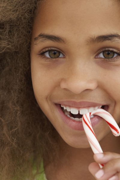 Close up of African American girl eating candy cane