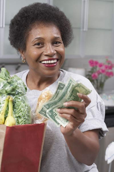 Senior African American woman with money and groceries
