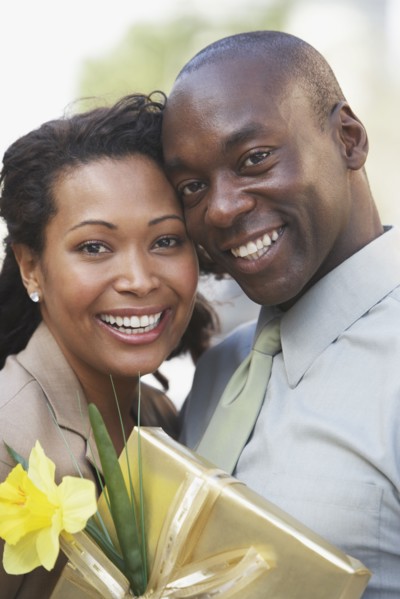 African couple hugging and holding gift