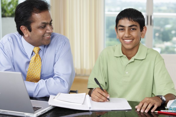 Middle Eastern father helping son with homework
