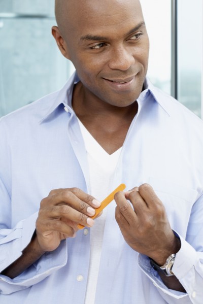 African American man filing fingernails