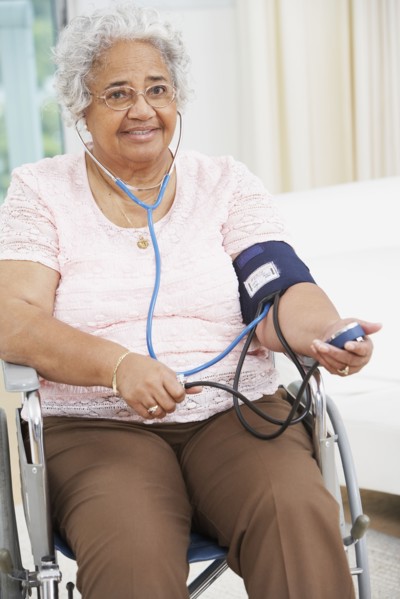 Senior African American woman taking own blood pressure
