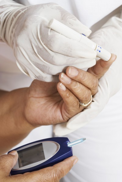 African American woman having blood sugar tested
