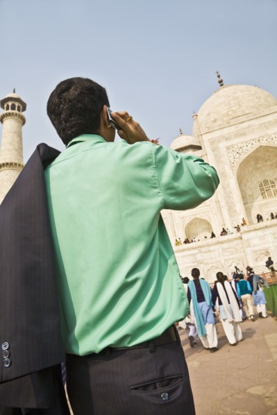 Indian businessman on cell phone visiting Taj Mahal